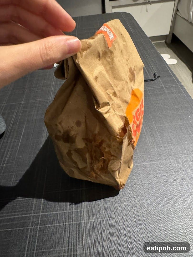 Hand holding fast-food bag
