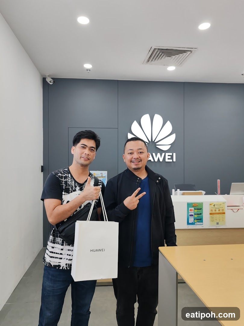 Two individuals posing in Huawei store interior