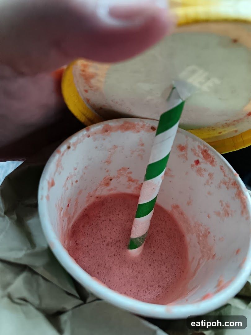 Pink beverage in disposable cup