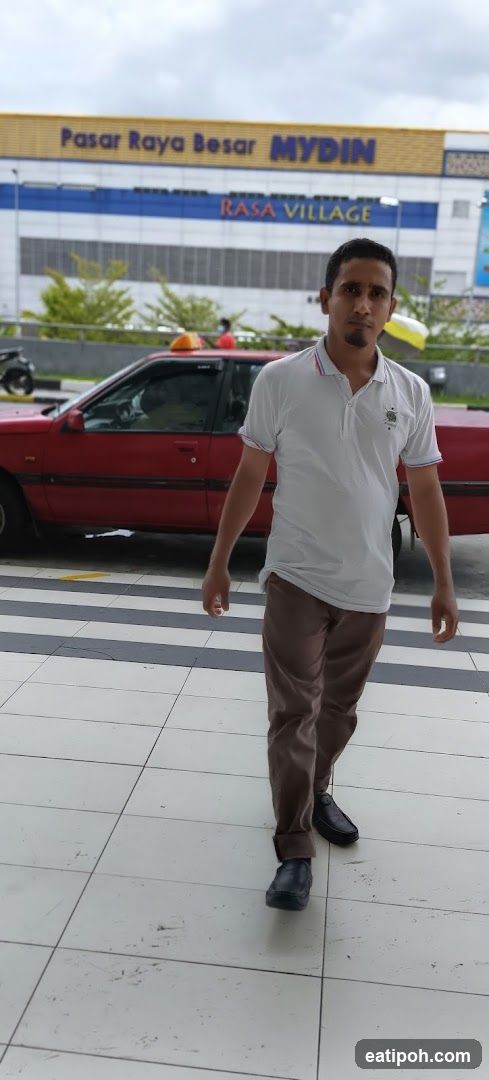 Man walking in front of Mydin supermarket