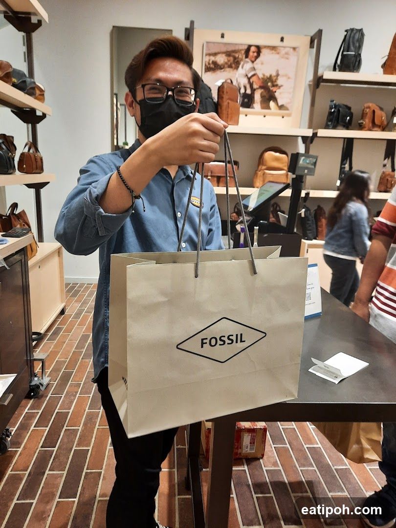 Man holding a Fossil shopping bag