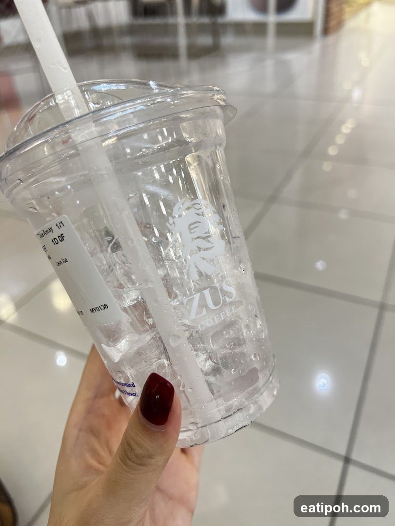 Hand holding a transparent cup with logo