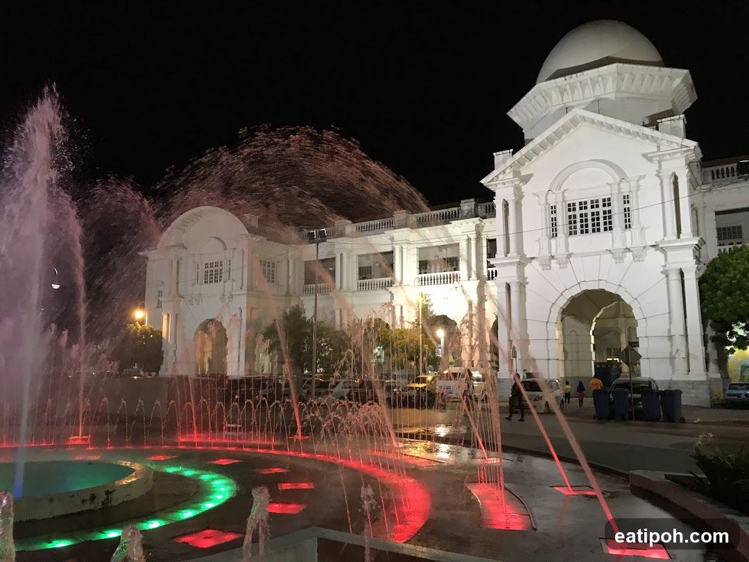 Nighttime fountain and colonial building