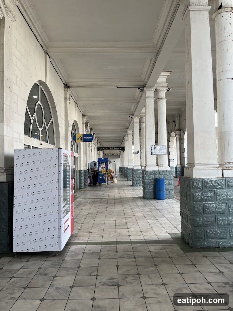 Interior corridor of a building with columns and tiled floor