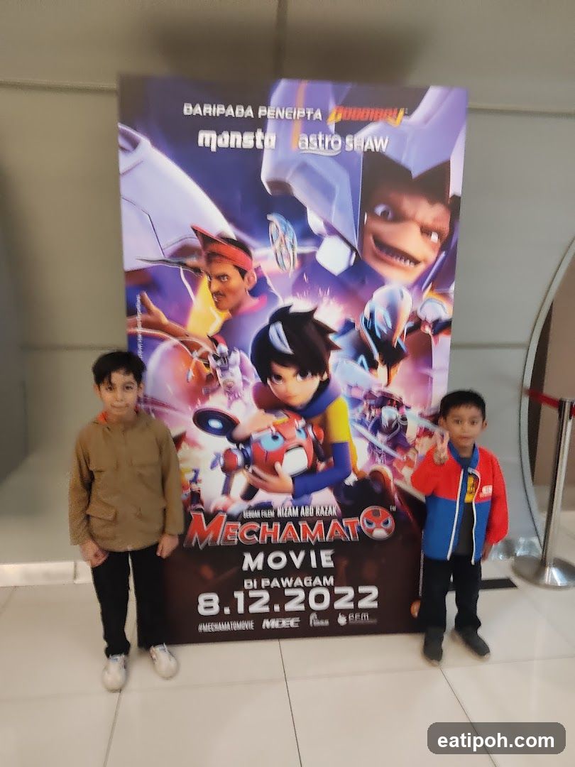 Two children posing in front of a movie poster