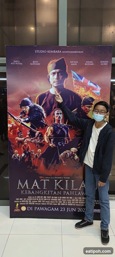 Movie Poster in Front of Cinema