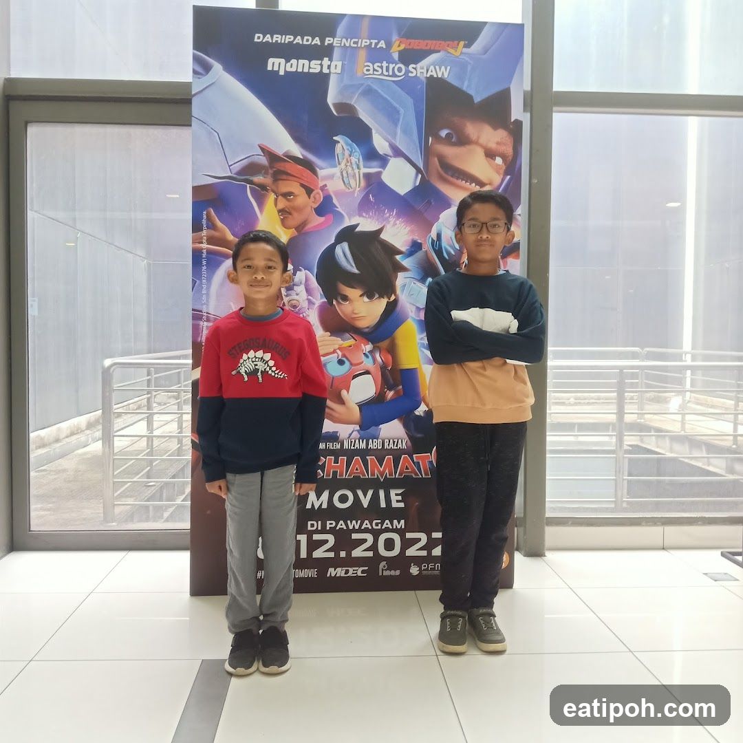 Two children posing in front of a movie poster