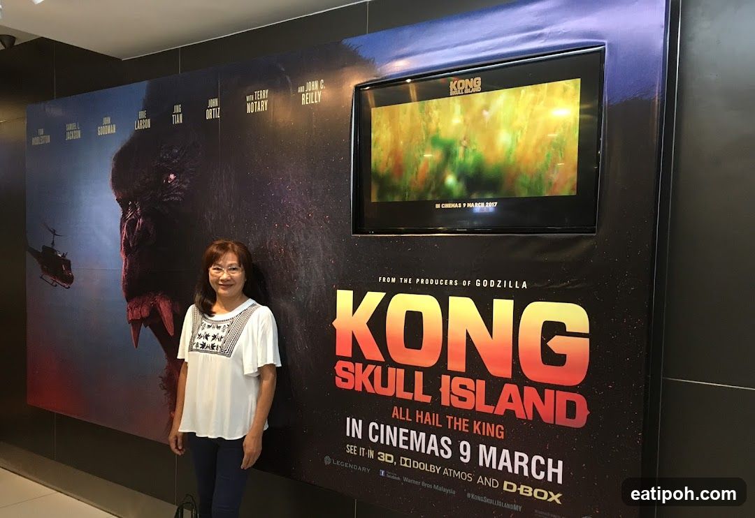 Woman standing beside movie poster