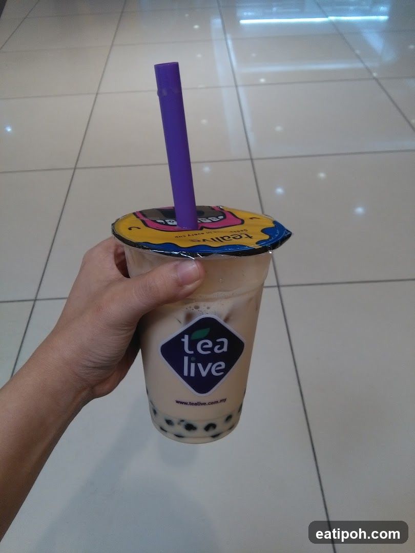 Hand holding a Tea Live bubble tea cup