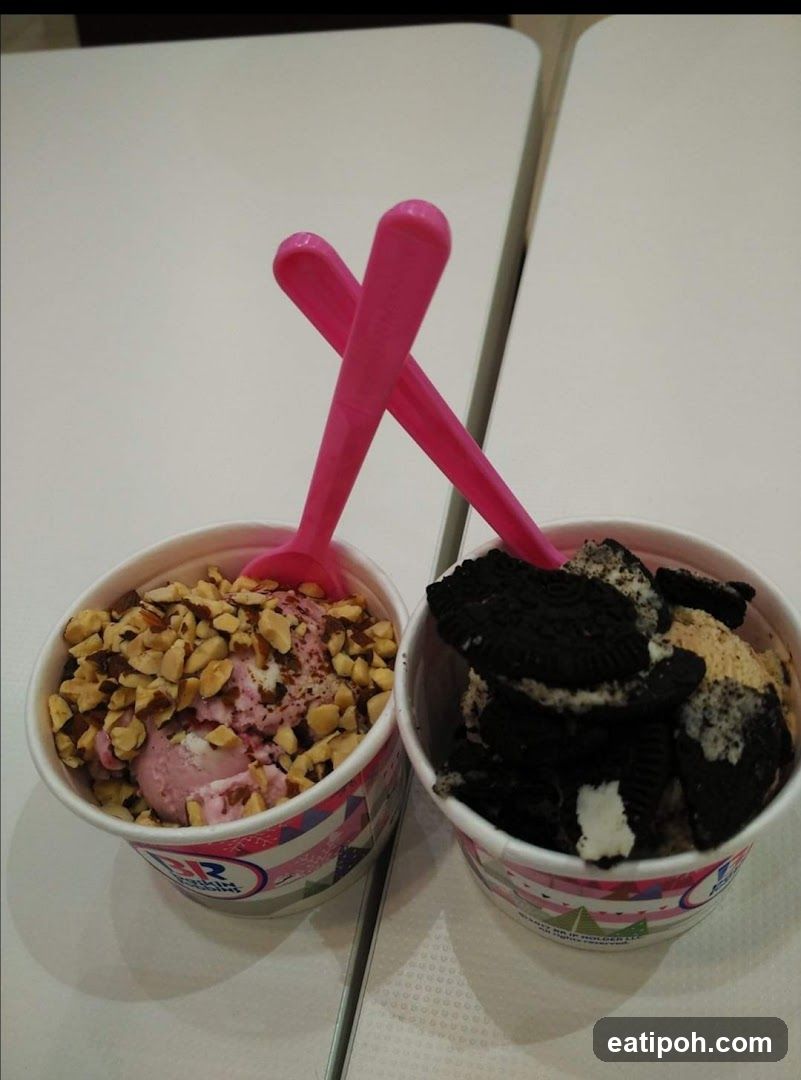 Two ice cream cups with pink spoons