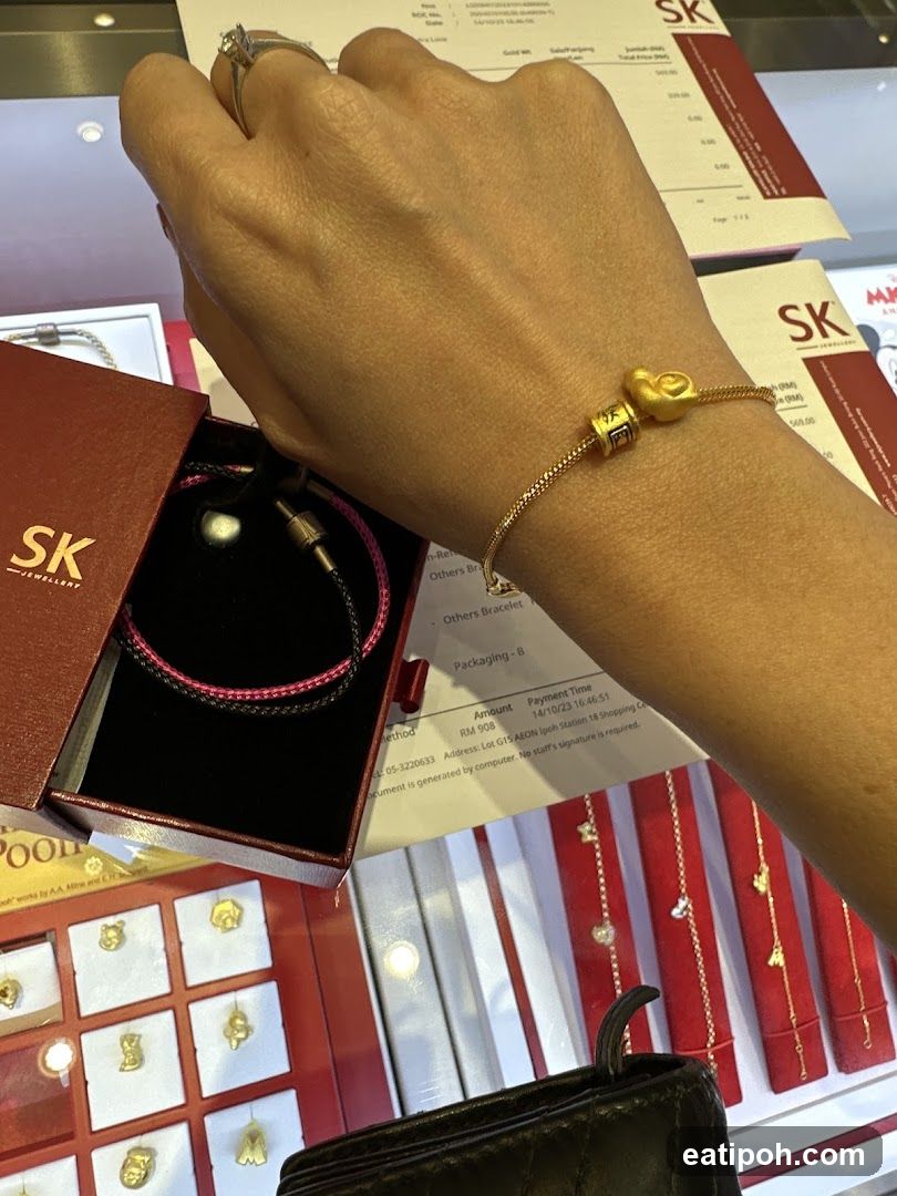 Hand wearing gold bracelet at jewelry store