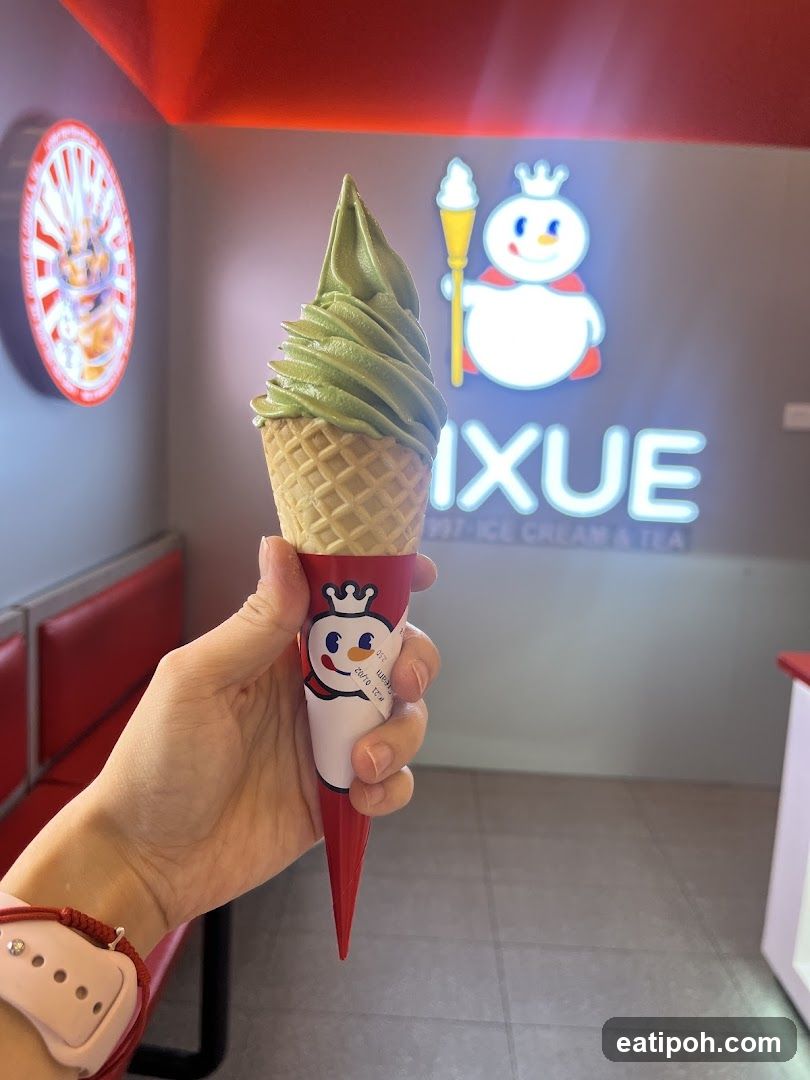 Hand holding ice cream cone inside shop