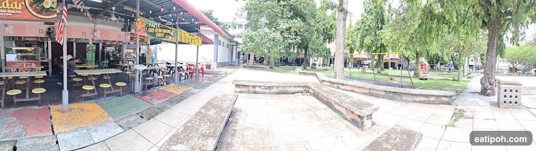 Outdoor food stall area with seating and playground