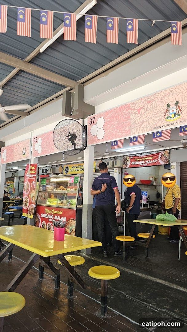 Food stall interior with Malaysian flags and staff
