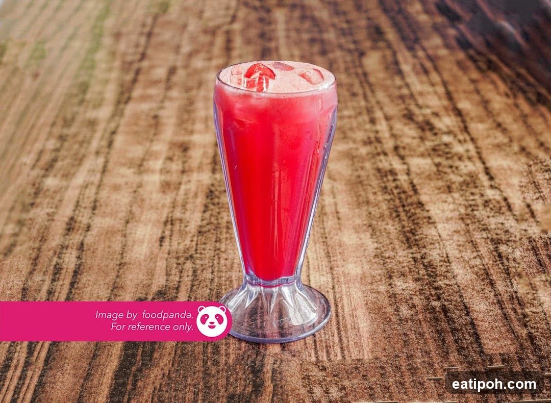 Red beverage in glass on wooden surface