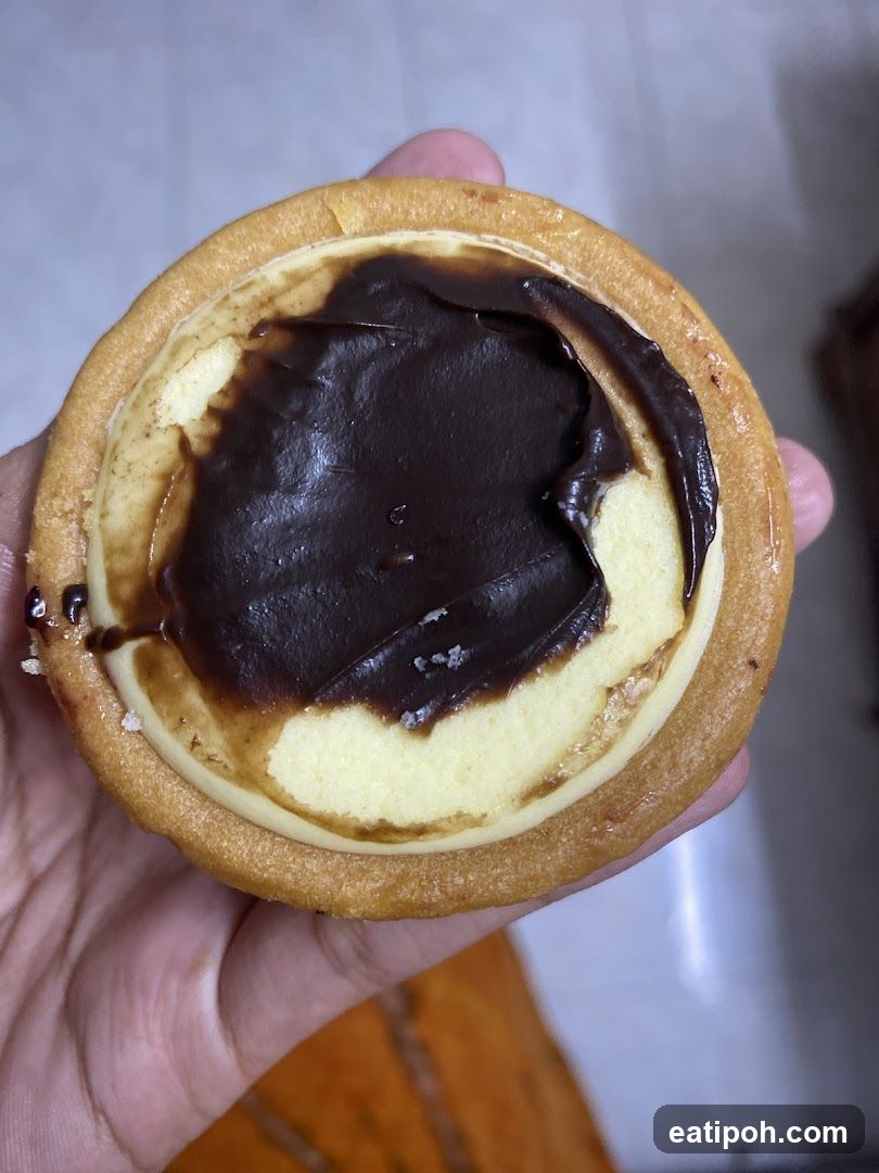 Hand holding chocolate-topped tart