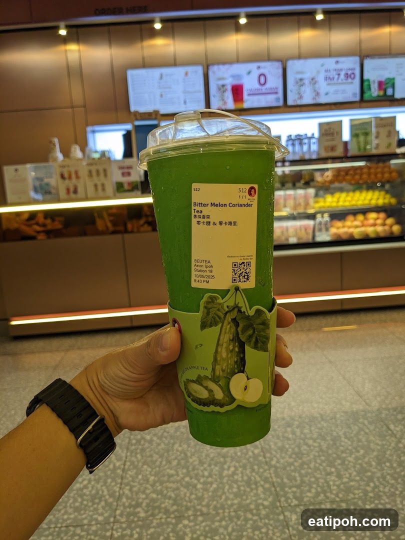Hand holding a Bitter Melon Coriander Tea cup