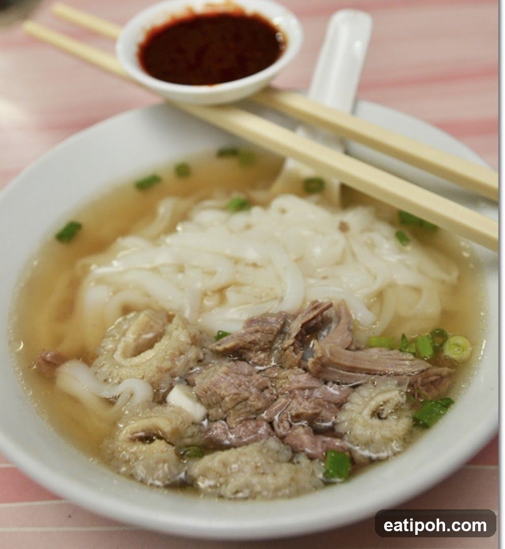 Bowl of noodle soup with chopsticks and dipping sauce
