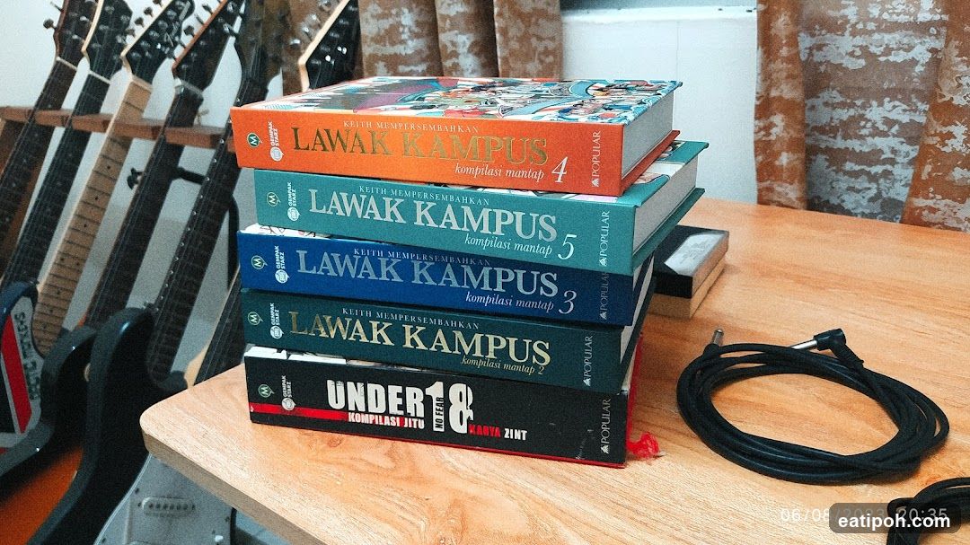 Books on Table with Guitars in Background