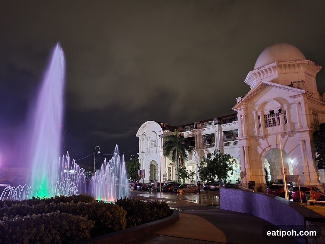 Nighttime fountain and colonial building