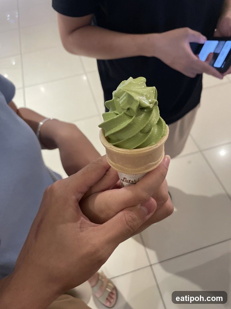 Hand holding green soft serve ice cream