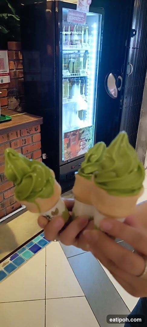 Matcha Ice Creams Held in Front of Beverage Cooler