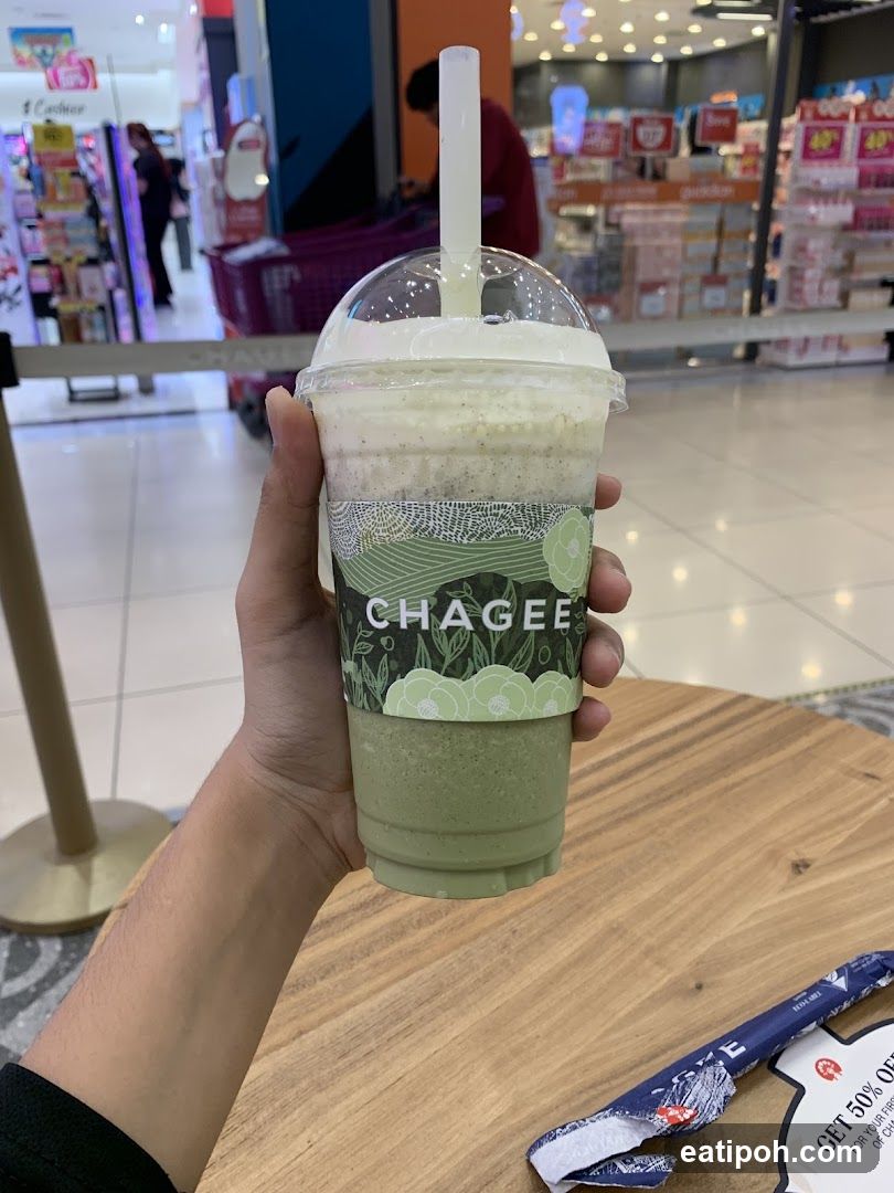 Hand holding Chagee drink in shopping mall