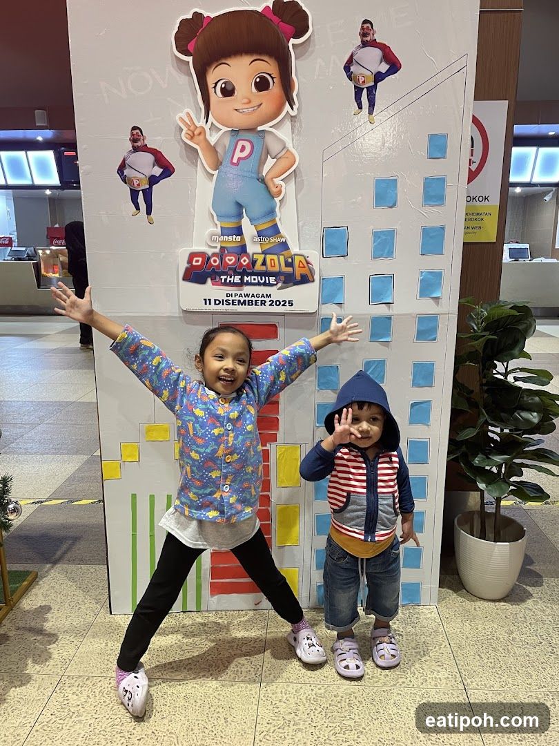 Children posing in front of movie promotional display