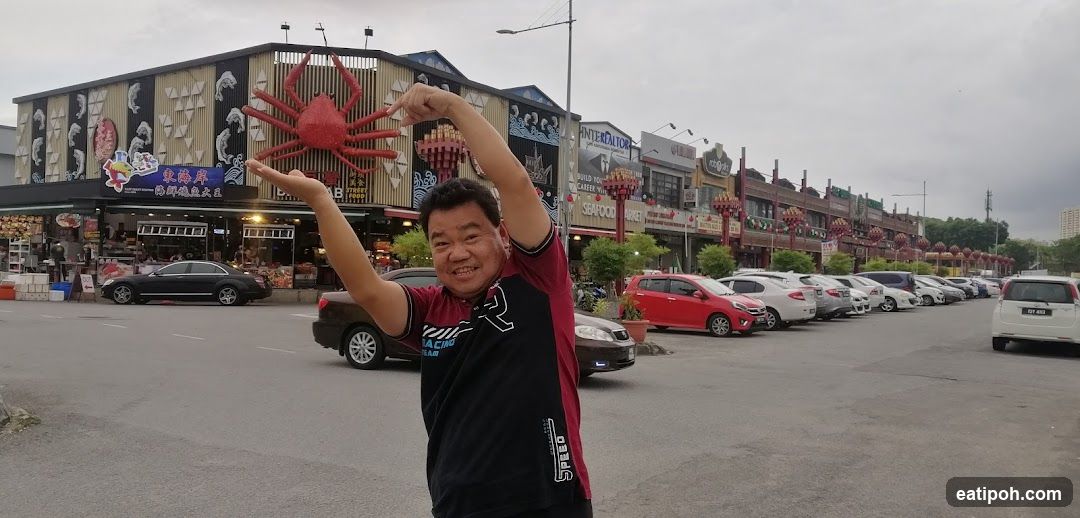 Man posing in front of seafood market building