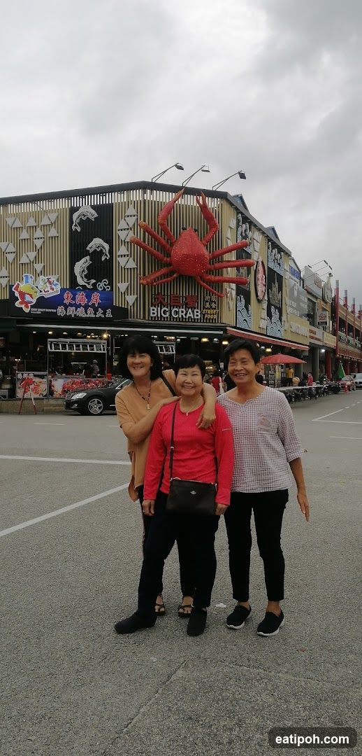 Three women posing in front of a seafood restaurant facade
