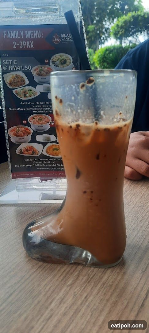 Iced beverage in boot-shaped glass at dining table