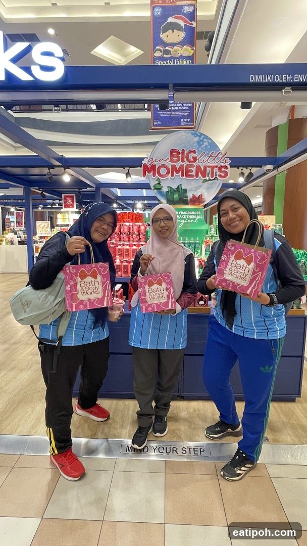 Three women posing with Bath & Body Works shopping bags