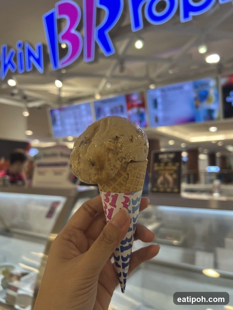 Hand holding ice cream cone in store