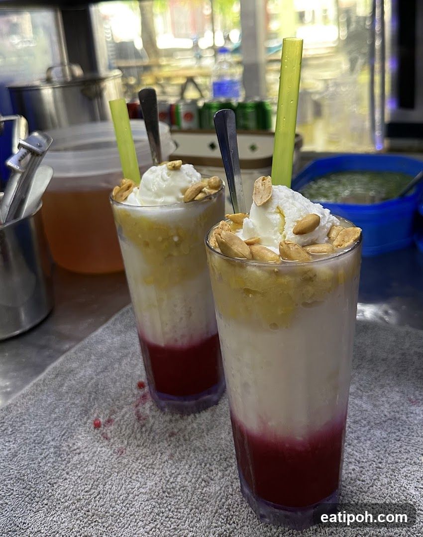 Two glasses of layered dessert with ice cream and peanuts