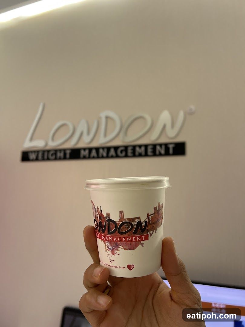 Hand holding branded cup in front of wall signage
