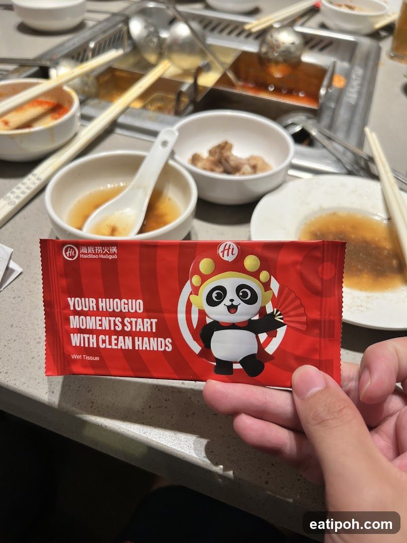 Hand holding wet tissue packet at hot pot restaurant