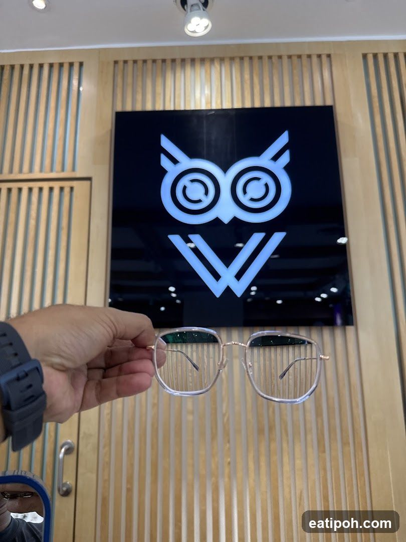 Hand holding glasses in front of store logo