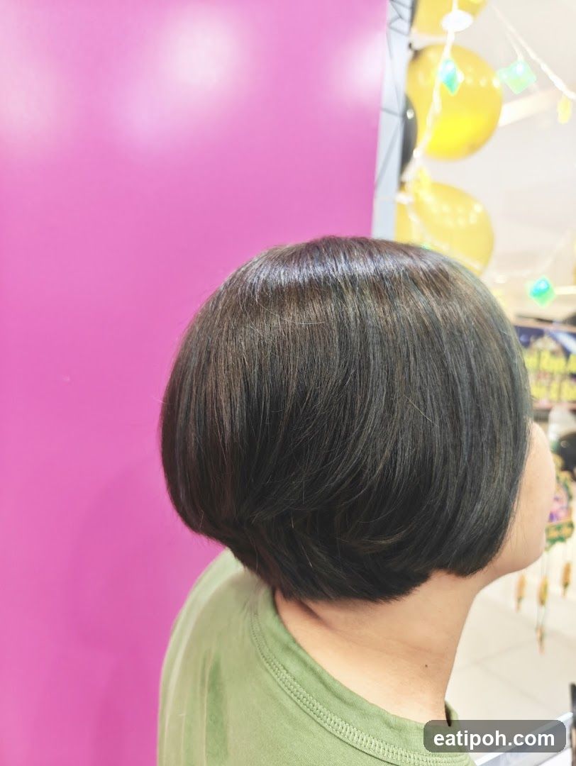 Person with short hair in front of pink wall