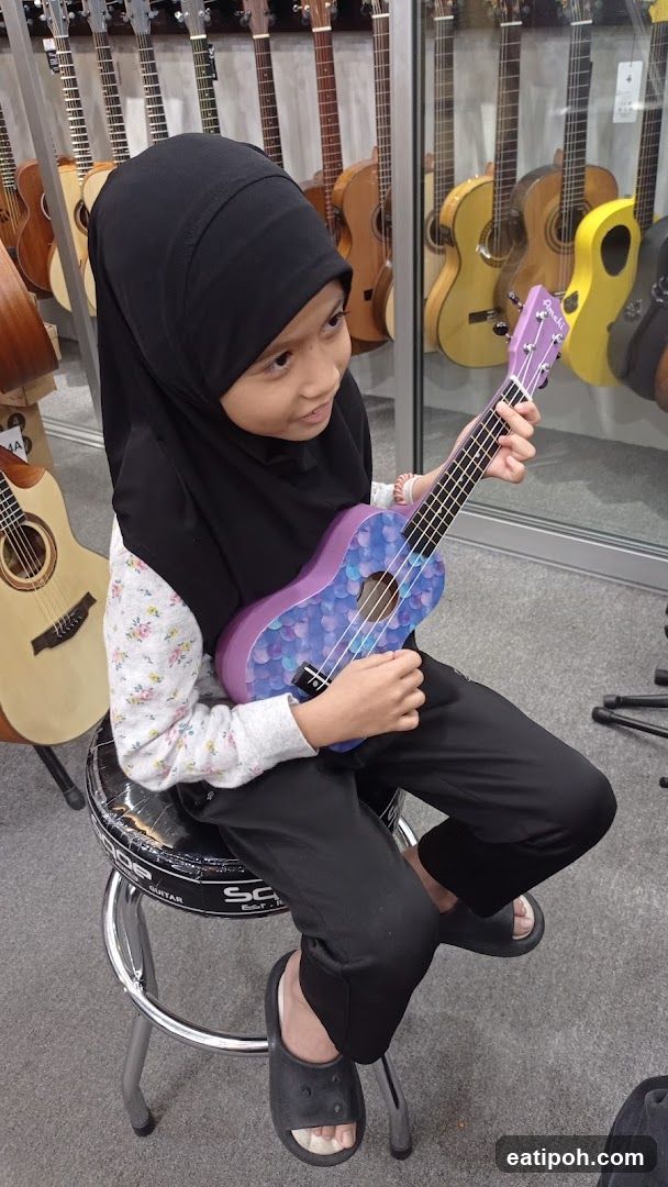 Child with ukulele in music store