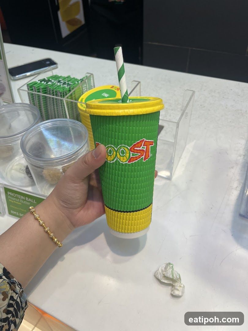 Hand holding Boost drink at counter