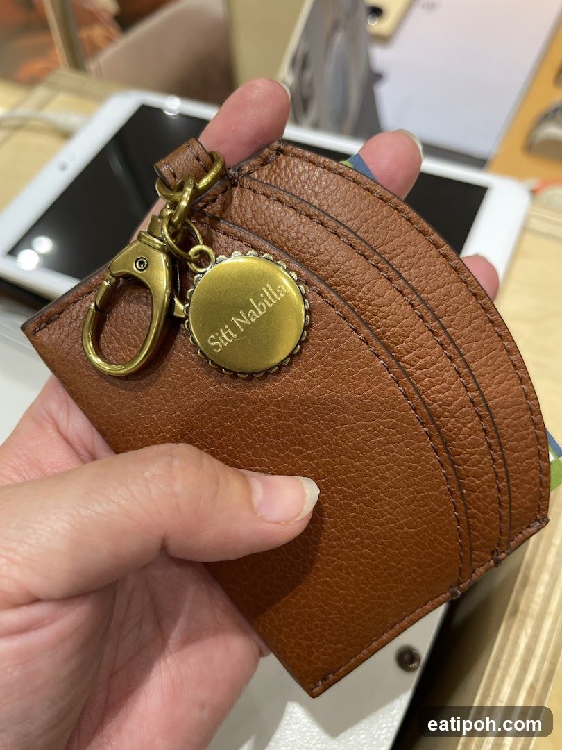 Hand holding leather cardholder with keychain