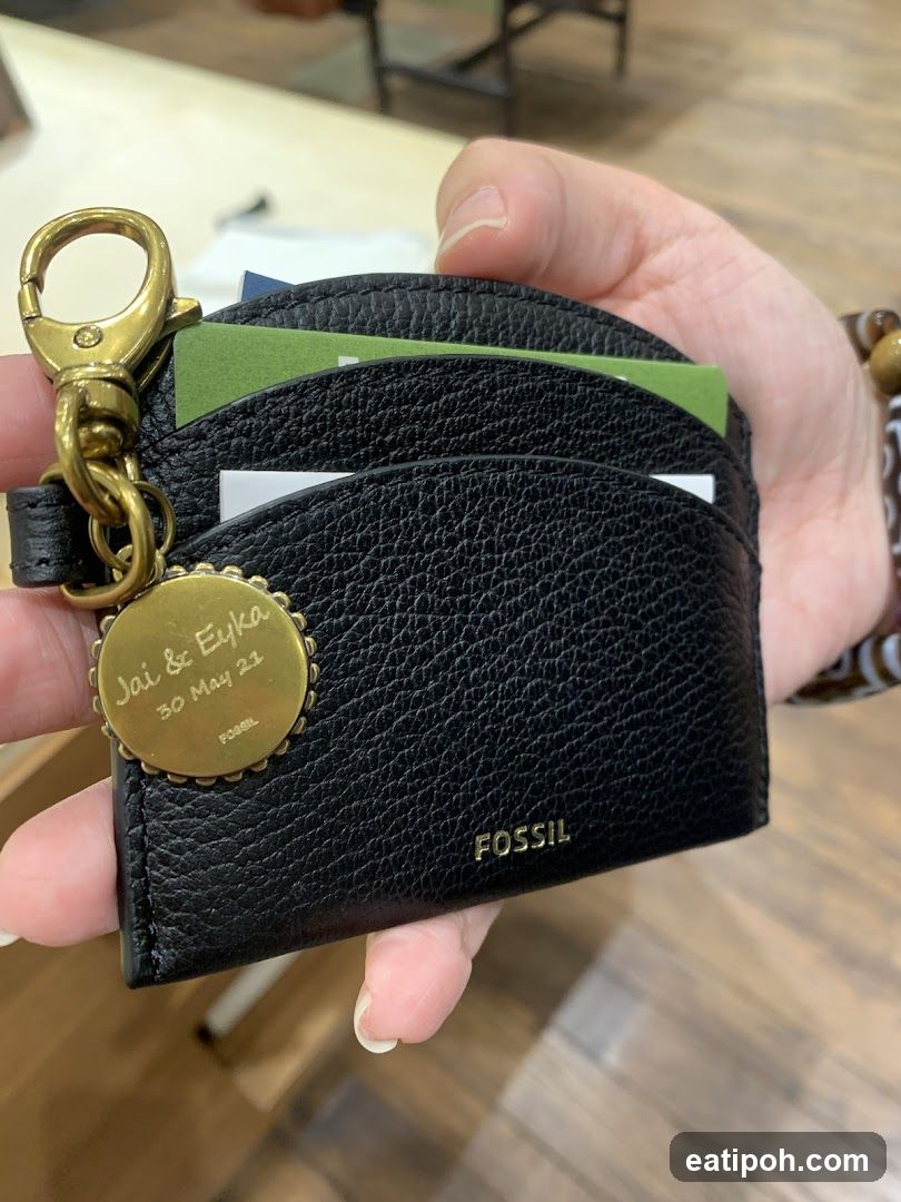 Hand holding Fossil wallet with keychain
