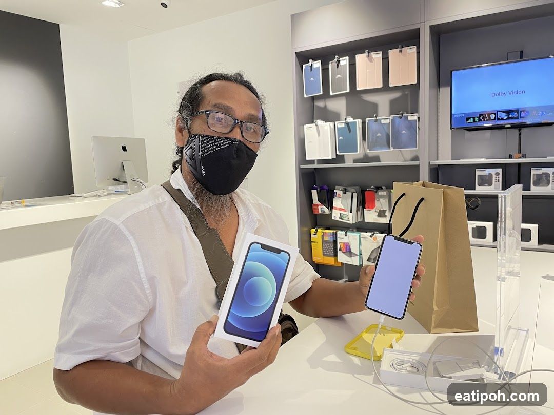 Man holding an iPhone box and phone