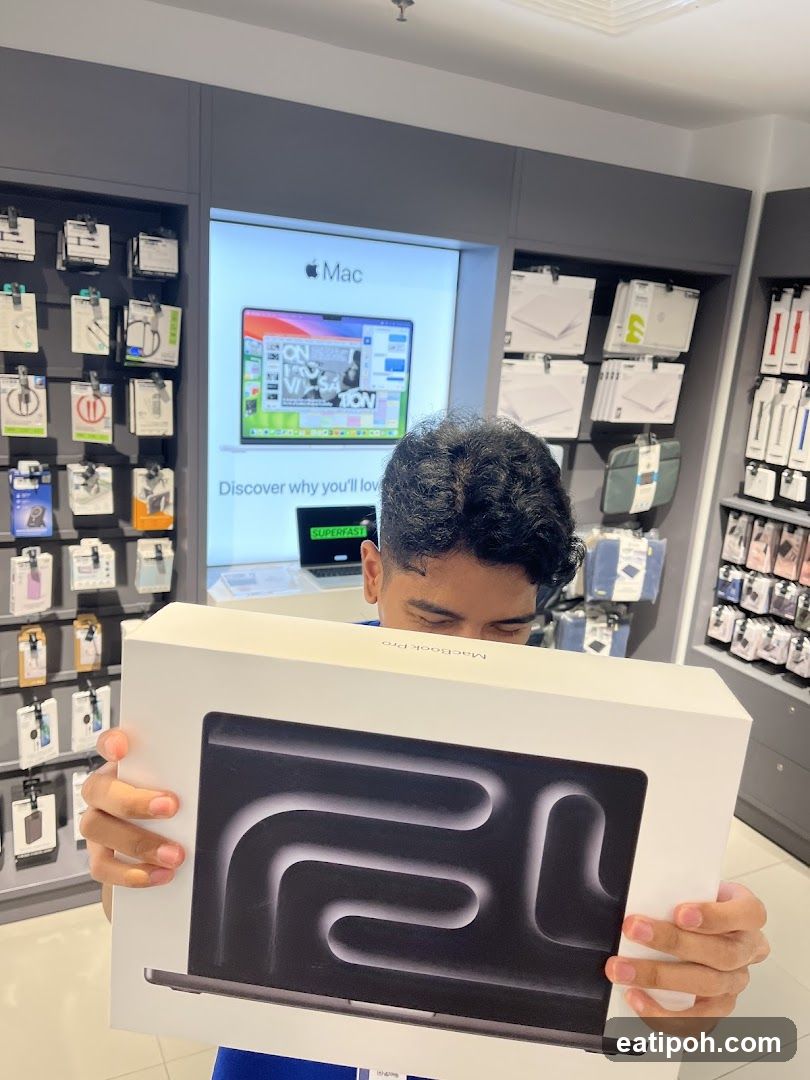 Person holding a MacBook Pro box in an Apple Store
