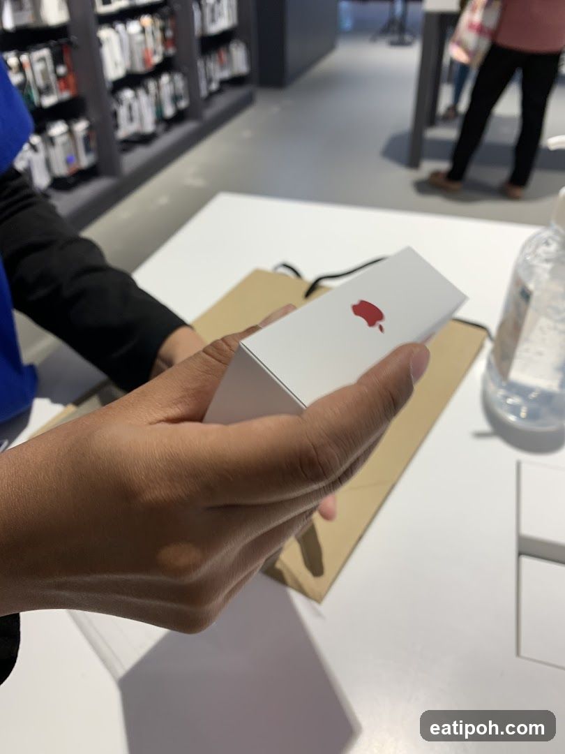 Person holding a product box with a red apple logo