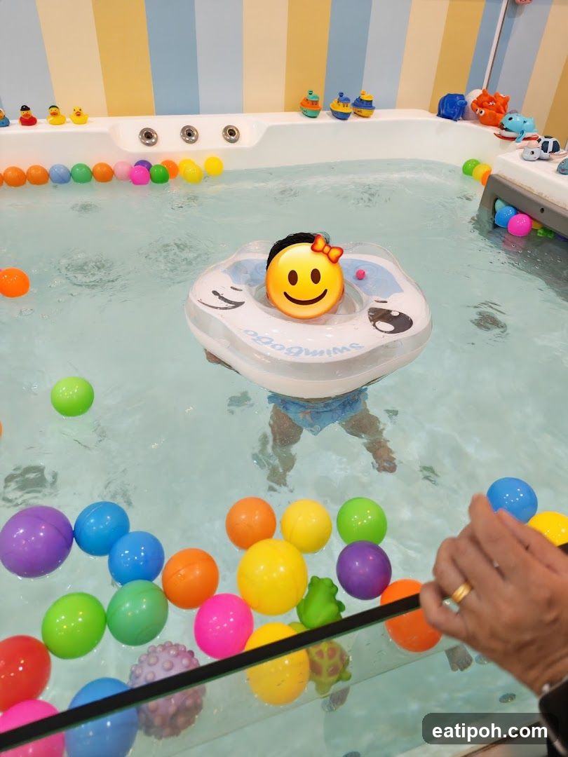 Baby in a swimming pool with colorful balls
