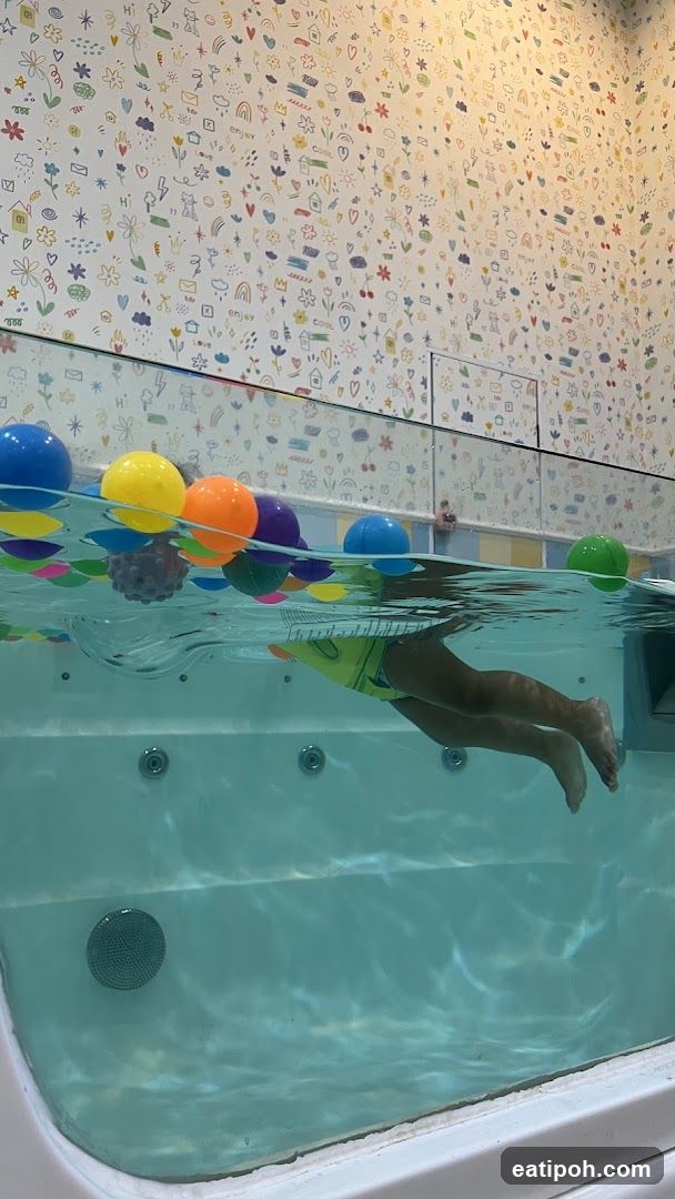 Child swimming in a pool with colorful balls