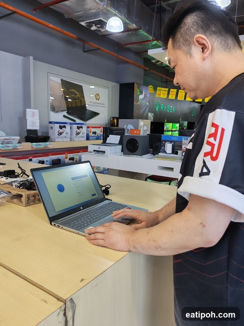 Man using a laptop in an electronics store
