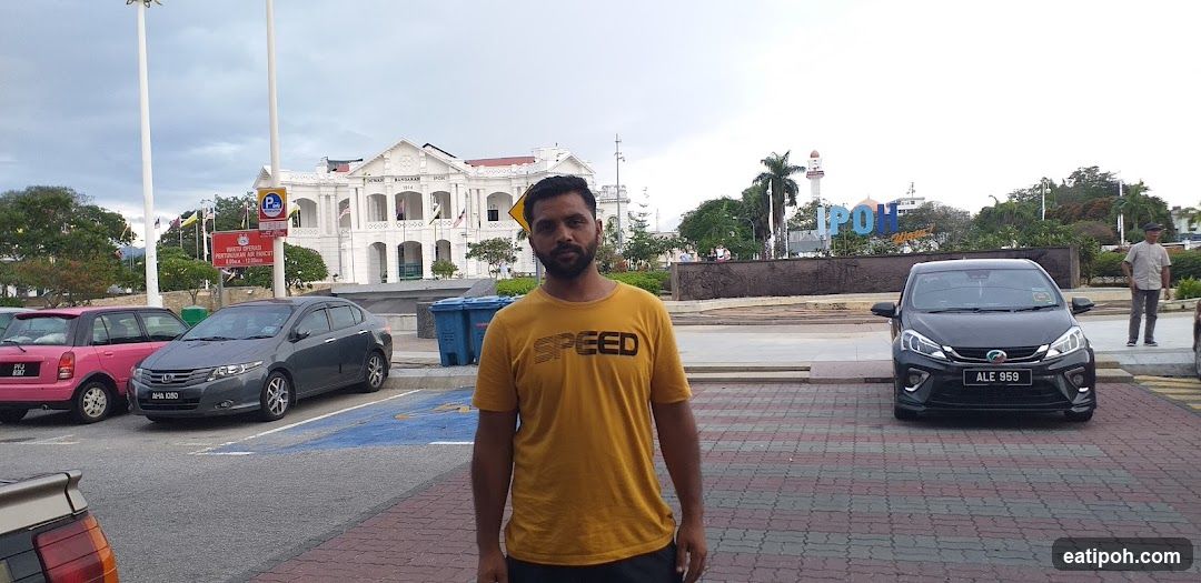 Man in Yellow T-shirt with IPOH Signage
