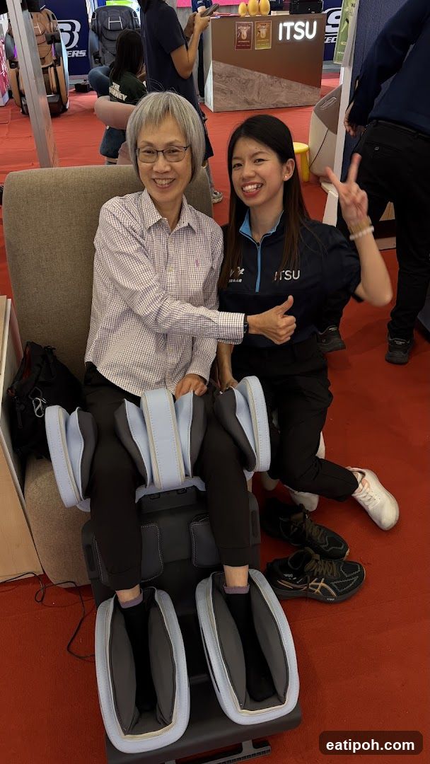 Two women posing with a massage chair